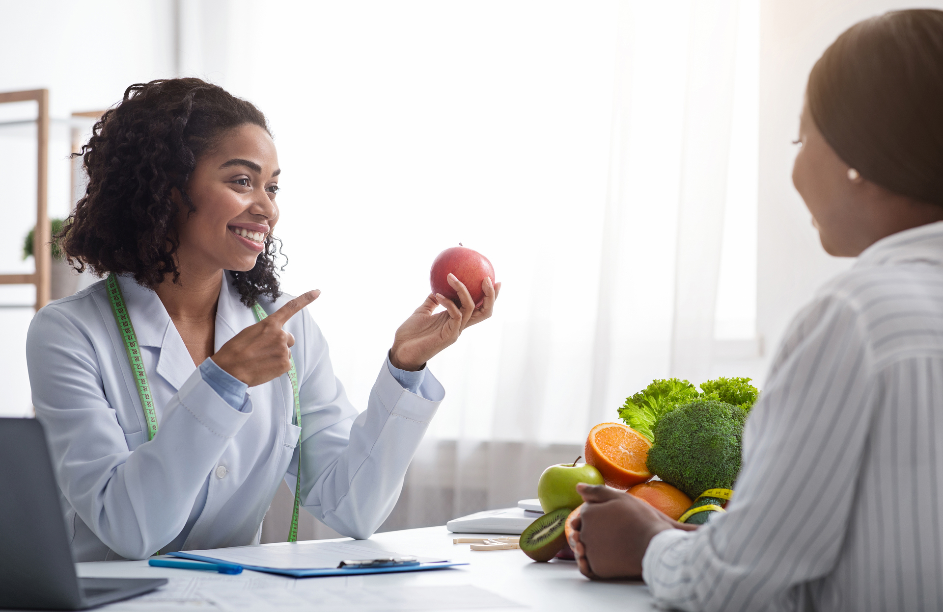 Pretty nutritionist giving consultation to patient about healthy feeding